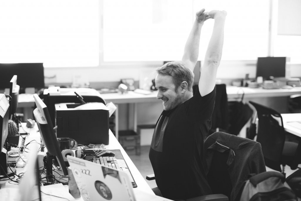 AIMS Accountants for Business - Man Stretching in front of his computer